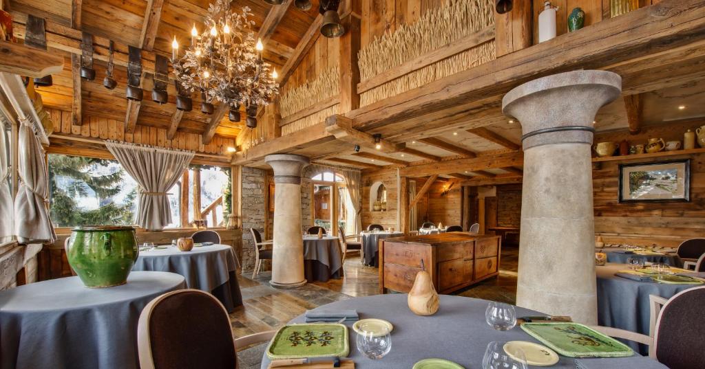 une salle à manger avec des tables et un lustre dans l'établissement La Bouitte - Hôtel Relais & Châteaux, à Saint-Martin-de-Belleville