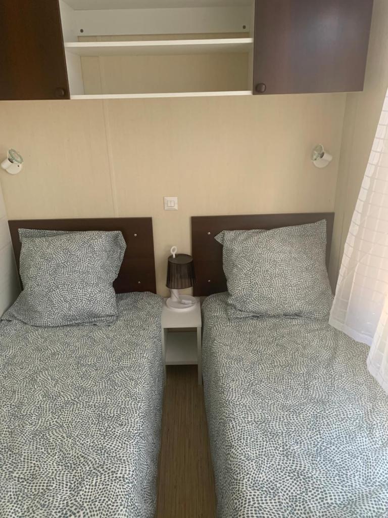 deux lits côte à côte dans une pièce dans l'établissement Flo mobil home camping Poney trois étoiles route de Moustiers Ste Croix, à Sainte-Croix-de-Verdon