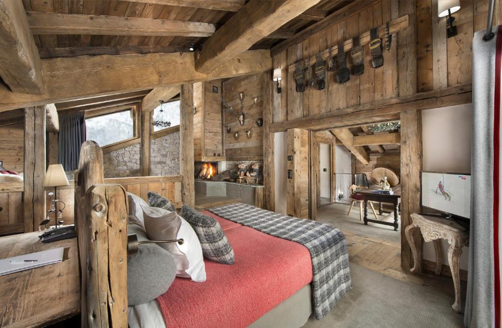 une chambre avec un lit dans une pièce aux murs en bois dans l'établissement La Bouitte - Hôtel Relais & Châteaux, à Saint-Martin-de-Belleville