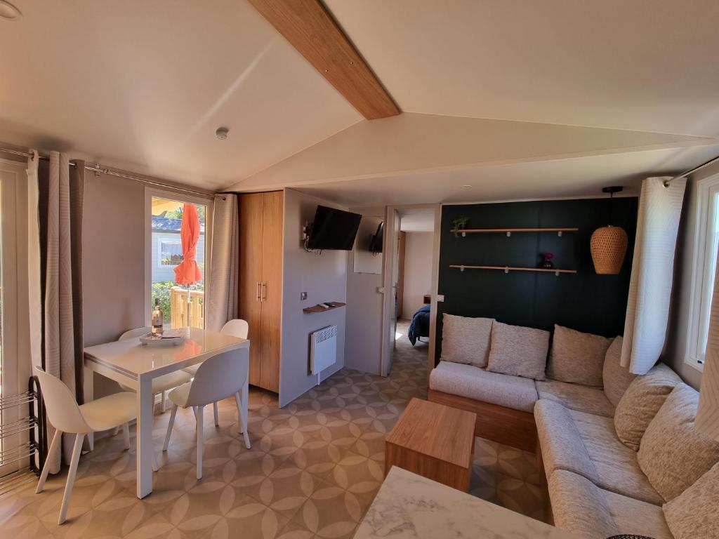 un salon avec un canapé et une table dans l'établissement Mobil-Home 419 Camping Lac des rêves proche de la mer, à Lattes