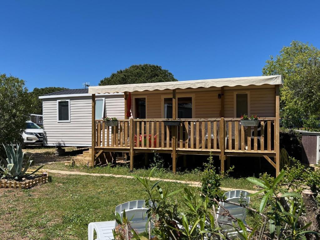 une petite maison avec un porche et une terrasse dans l'établissement Mobil-Home 419 Camping Lac des rêves proche de la mer, à Lattes