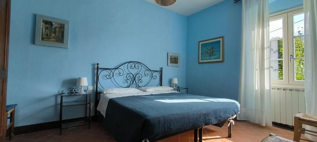 une chambre bleue avec un lit avec un mur bleu dans l'établissement La Gropina Di Loro Ciuffenna, à Loro Ciuffenna