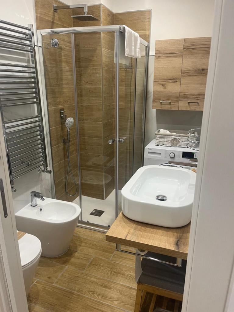 une salle de bain avec douche, lavabo et toilettes dans l'établissement Residenza Cristforo Colombo, à Crotone 1 autre photo