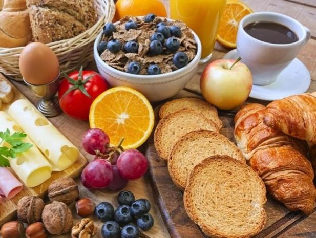 - une table de petit-déjeuner avec du pain, des fruits et des œufs dans l'établissement Wildberry cycling, à Lignieres-Orgeres