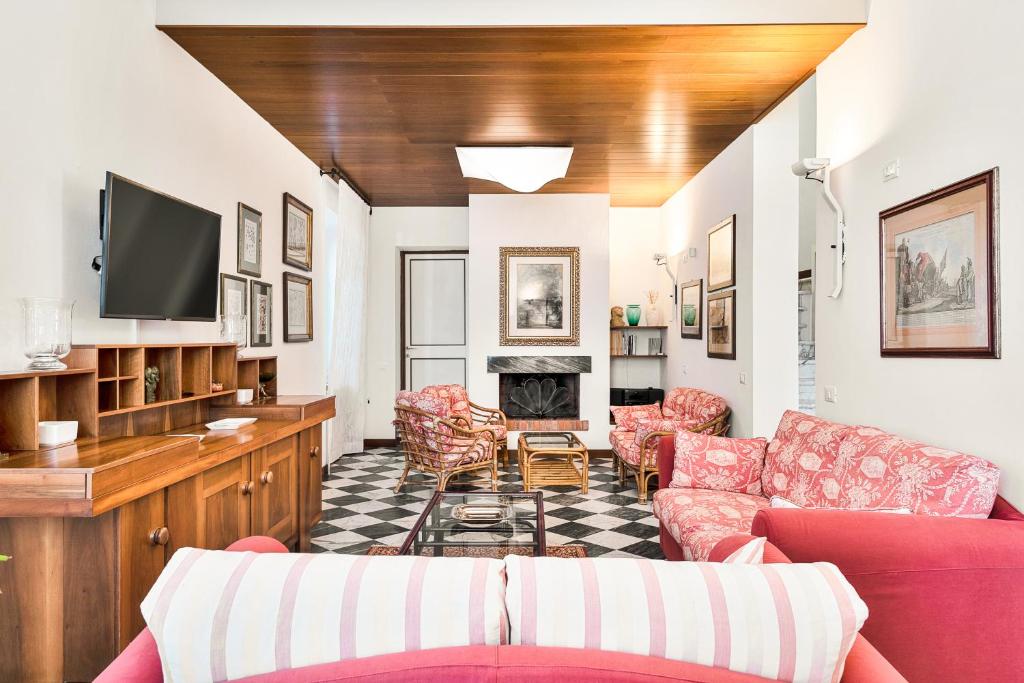 - un salon avec des canapés rouges et une télévision dans l'établissement Villa Cà ai Venti, à Corsanico-Bargecchia