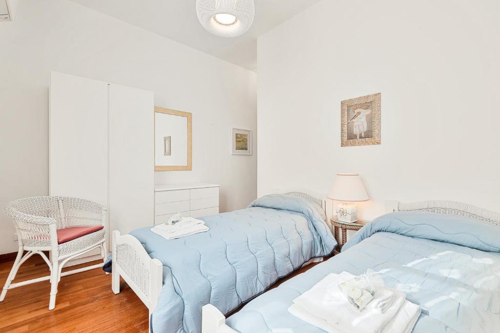 - une chambre avec 2 lits et une chaise dans l'établissement Villa Cà ai Venti, à Corsanico-Bargecchia