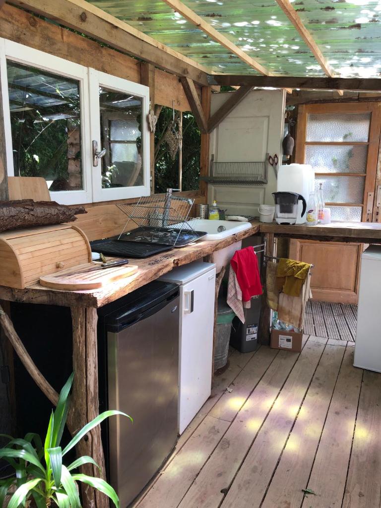- une cuisine dans un salon avec une terrasse en bois dans l'établissement Yourte dans la forêt, à Rennes-les-Bains