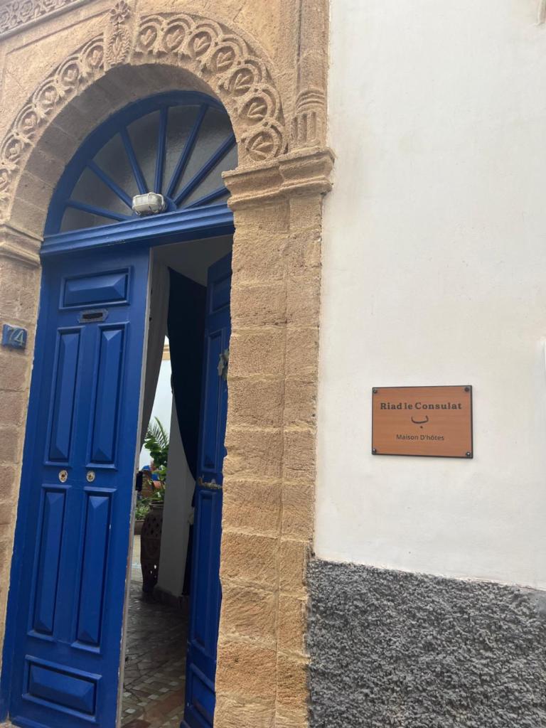 une porte bleue avec un panneau sur un bâtiment dans l'établissement Riad le Consulat - chambre d'hôtes, à Essaouira 34 autres photos