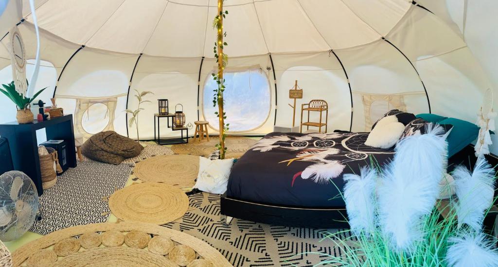 une chambre avec un lit dans une tente dans l'établissement Domaine la Madeleine - Hébergement insolite, à Aubagne