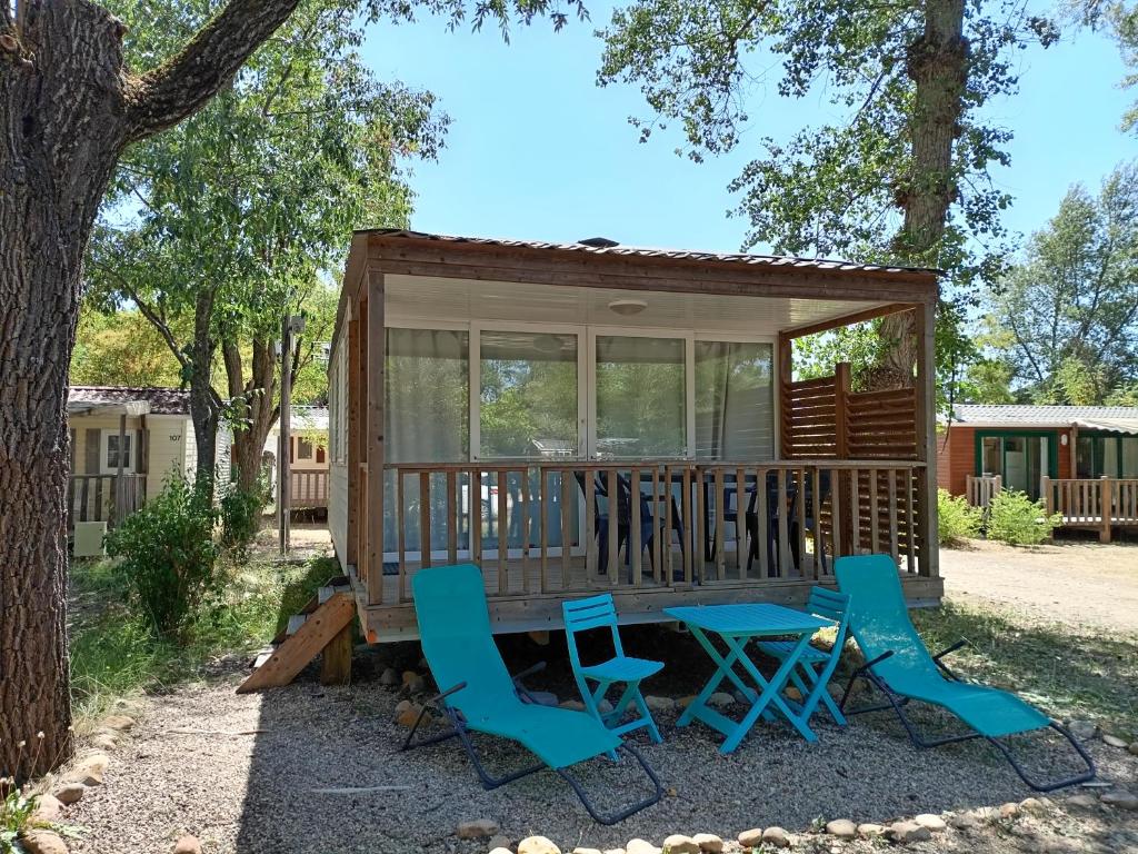 une petite maison avec une table et des chaises sur une terrasse dans l'établissement Mobil-home, à Beynes