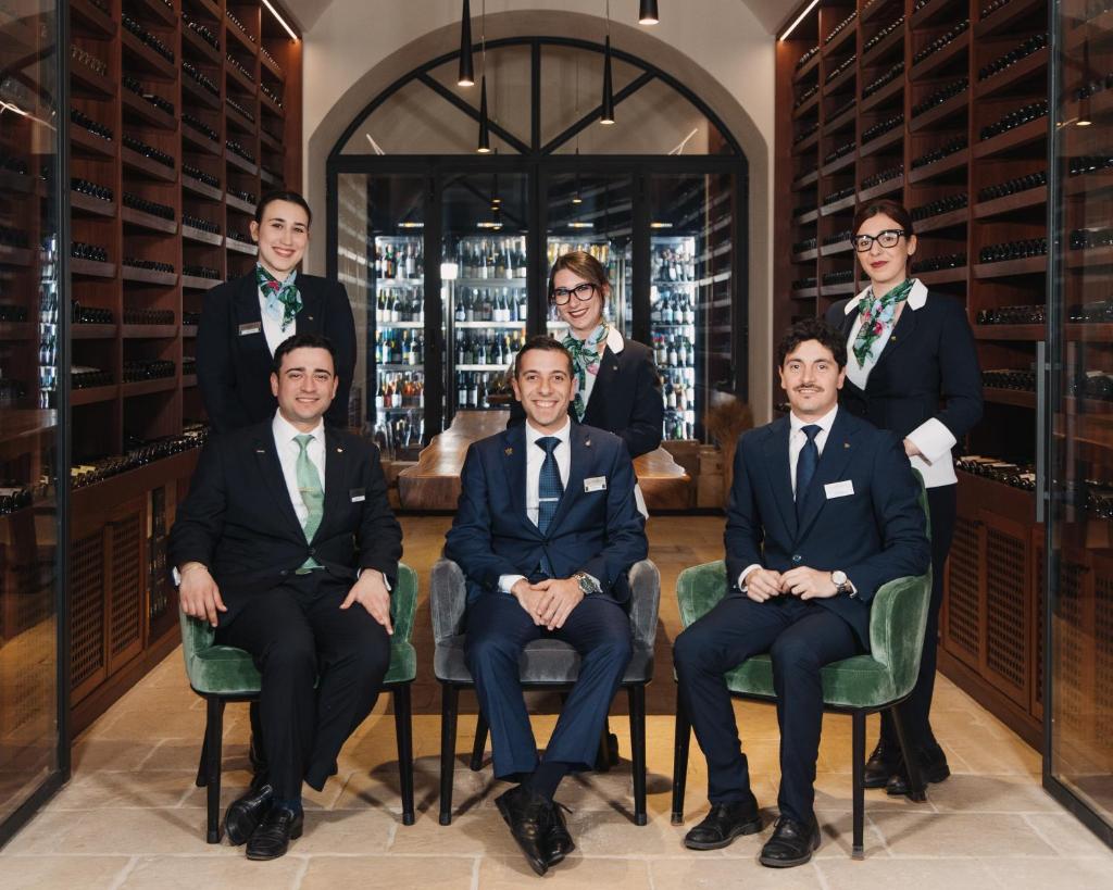 un groupe d'hommes en costumes assis dans une cave à vin dans l'établissement Il San Corrado di Noto, à Noto 174 autres photos