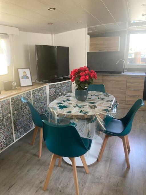 une table avec des chaises et un vase de fleurs dessus dans l'établissement Une nuit, la vie avec Marie Lou, à Venette