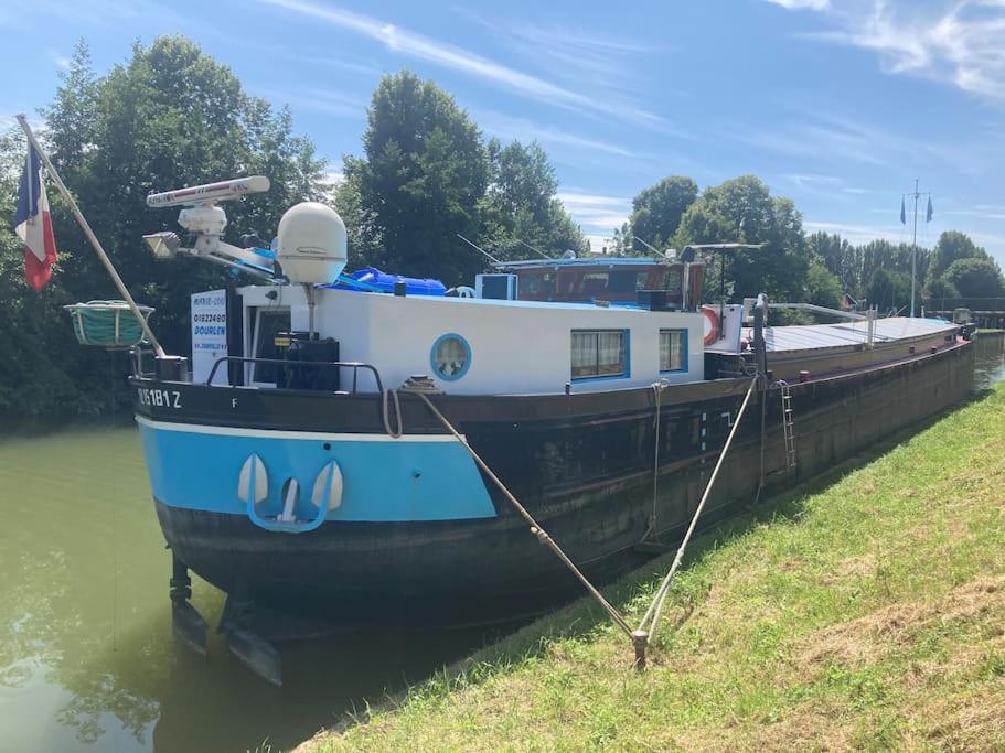 un bateau bleu et blanc assis dans l'eau dans l'établissement Une nuit, la vie avec Marie Lou, à Venette