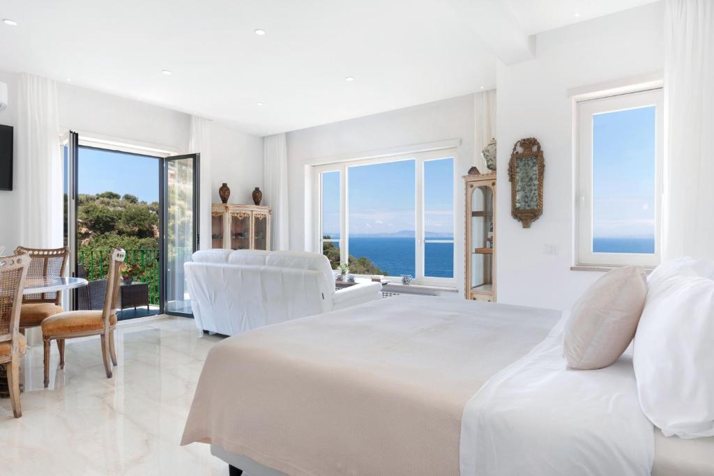 une chambre blanche avec un lit et une vue sur l'océan dans l'établissement Hotel Desiree, à Sorrente