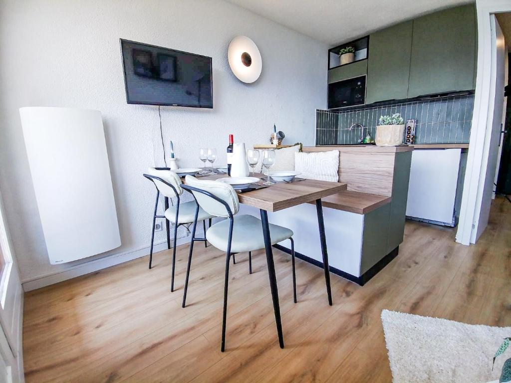 - une table à manger et des chaises dans la cuisine dans l'établissement La Montagnarde avec vue imprenable - station Doucy Valmorel - 4pers, à La Lechere