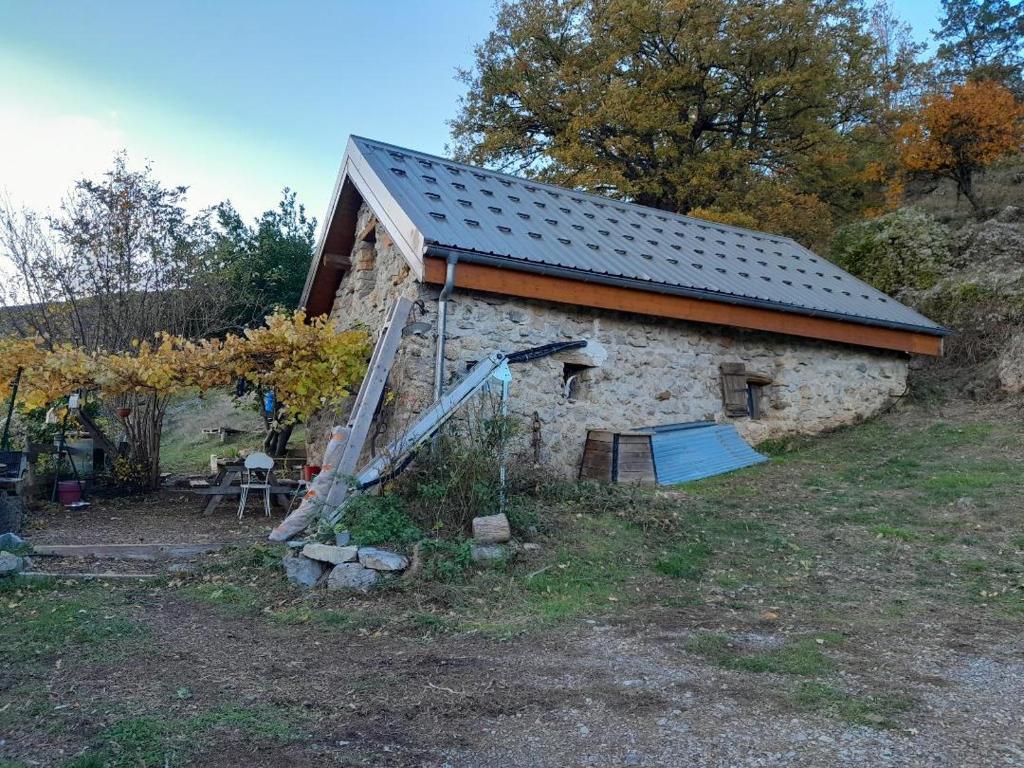 un petit bâtiment en pierre avec un toit en métal dans l'établissement Altitude Ecolodge Yourte, à Ilonse 7 autres photos
