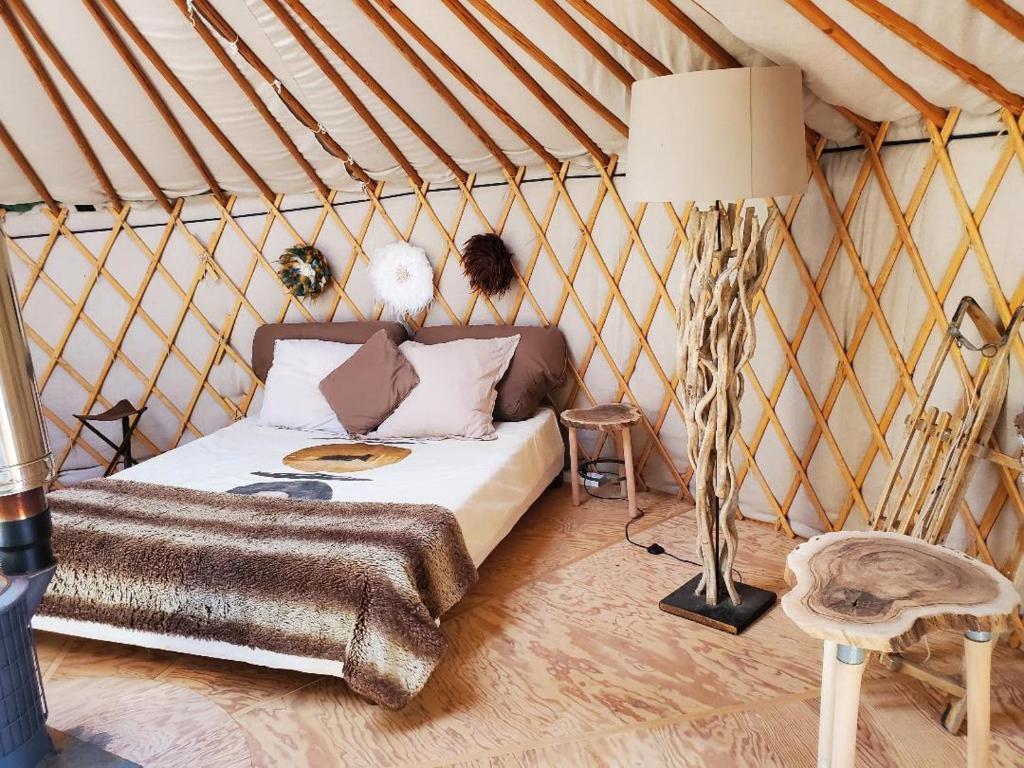 une chambre avec un lit dans une yourte dans l'établissement Altitude Ecolodge Yourte, à Ilonse