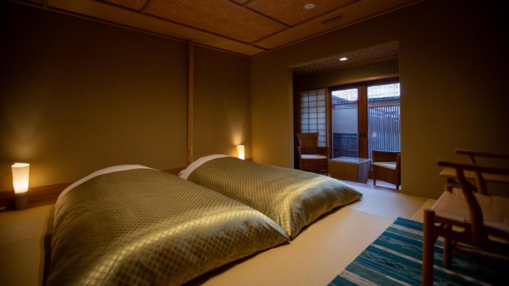 une chambre avec un lit et une grande fenêtre dans l'établissement Itsukushimahigashimonzen Kikugawa, à Miyajima