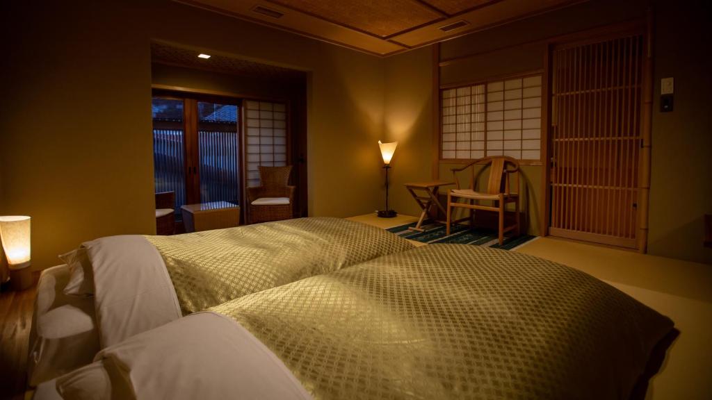 une chambre avec deux lits dans une pièce dans l'établissement Itsukushimahigashimonzen Kikugawa, à Miyajima