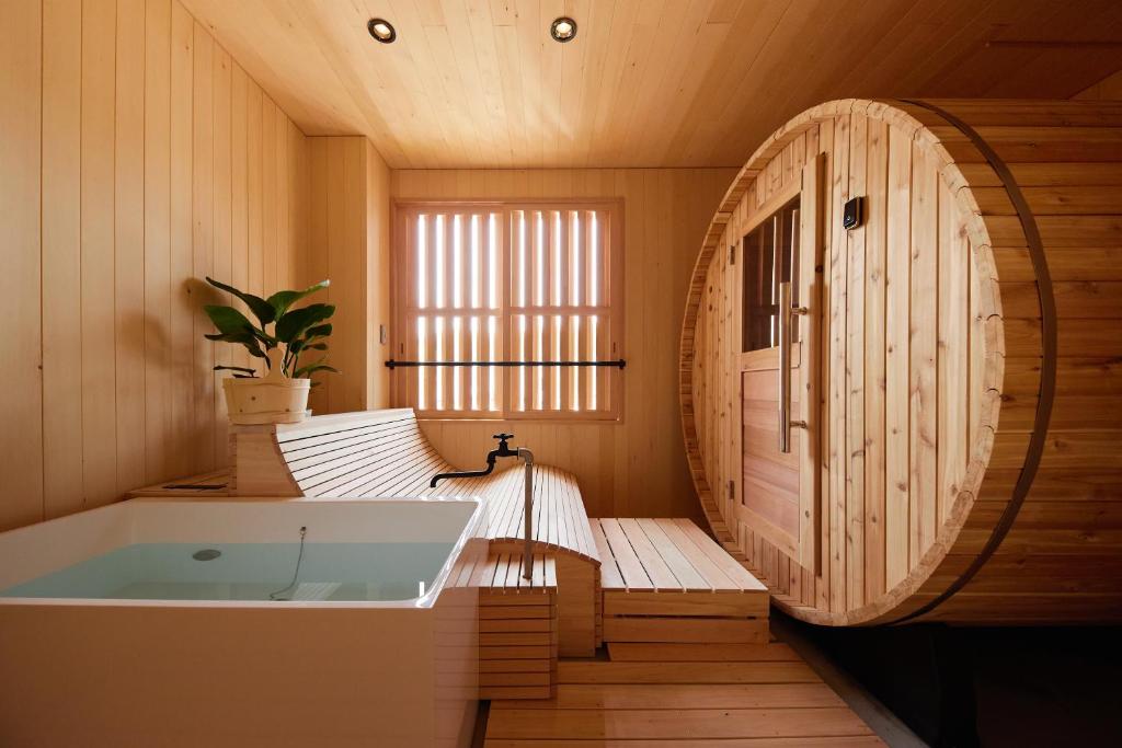 Cette chambre en bois comprend une salle de bains pourvue d'une baignoire. dans l'établissement Akiu Fuga, à Sendai