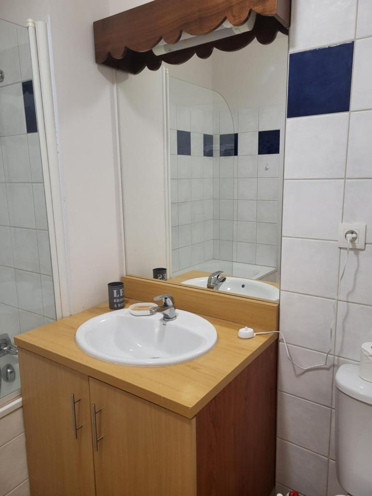 une salle de bain avec un lavabo et un miroir dans l'établissement Chez Virginie cocon familial, à Ustou
