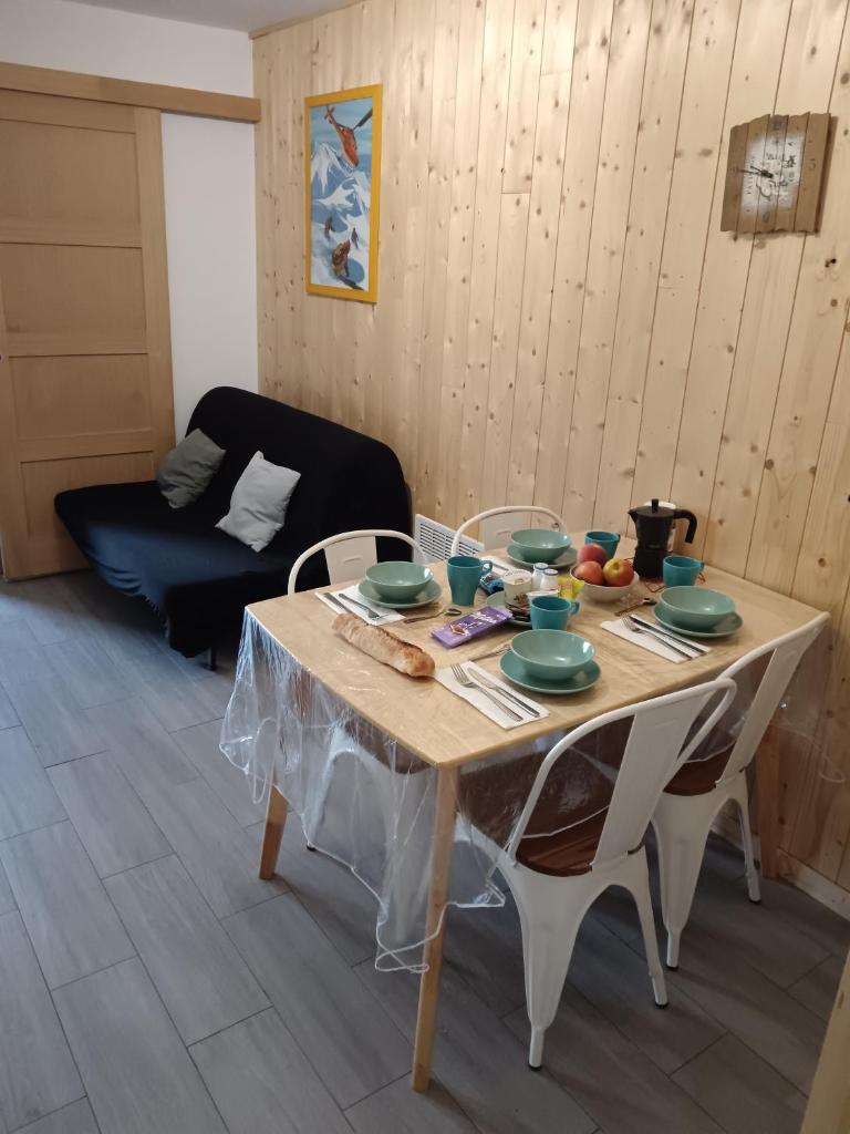 - une table avec des assiettes et des bols dans le salon dans l'établissement Appartement plein sud, Val Thorens Centre, à Val Thorens