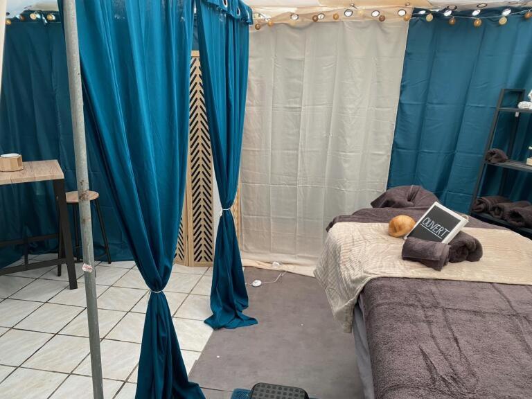 une chambre avec des rideaux bleus et un lit avec un livre dans l'établissement Camping L'oasis Du Berry, à Saint-Gaultier 37 autres photos