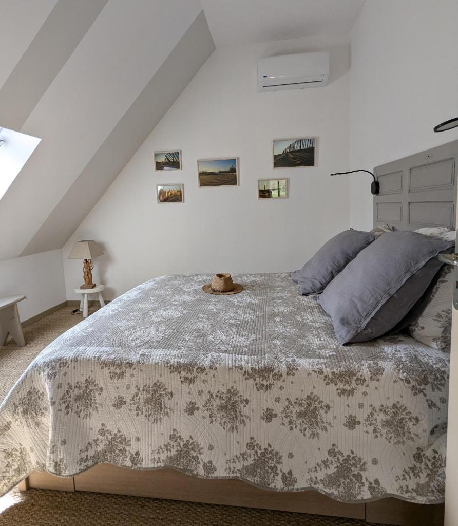 une chambre avec un lit avec un couvre-lit blanc dans l'établissement Les Pierres Lotoises - gîte les grandes pierres, à Reilhaguet