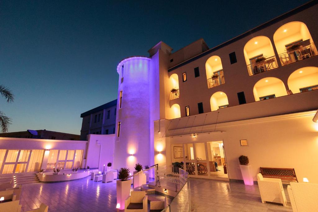 un bâtiment avec une tour éclairée devant lui dans l'établissement Hotel Poseidonia Mare, à Paestum