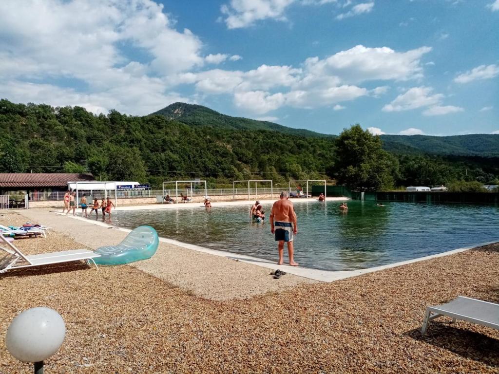 un homme debout dans l'eau à la piscine dans l'établissement Mobil-home, à Beynes 6 autres photos