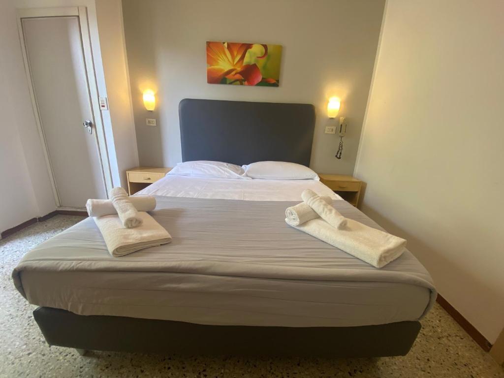 une chambre avec un lit avec deux serviettes dessus dans l'établissement Hotel Ausonia B&B RiMiNi, à Rimini