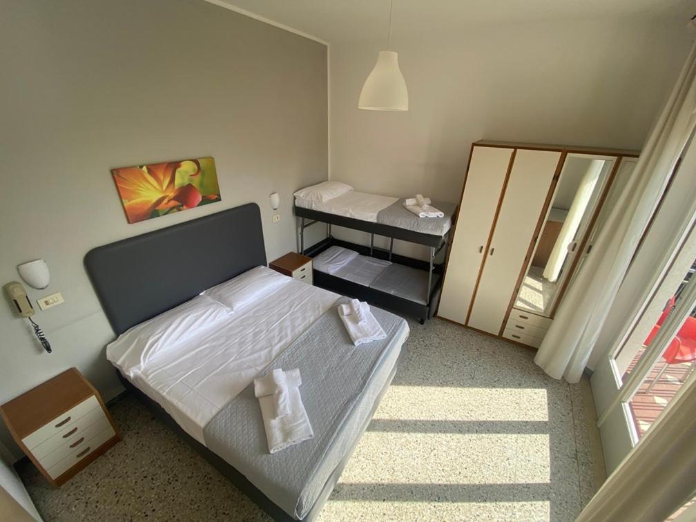 une petite chambre avec un lit et un miroir dans l'établissement Hotel Ausonia B&B RiMiNi, à Rimini