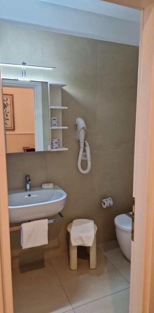 une salle de bain avec un lavabo et des toilettes dans l'établissement Hotel Progresso, à San Benedetto del Tronto