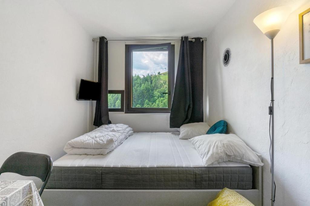 une petite chambre avec un lit et une fenêtre dans l'établissement Appartement Cosy- Villarembert, à Villarembert
