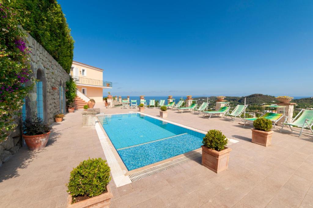 - une piscine sur une terrasse avec des chaises longues dans l'établissement Poggio Del Sole, à Ischia