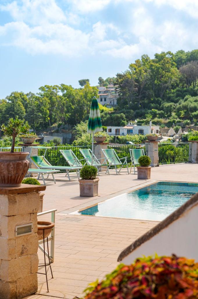 une piscine avec des chaises longues et une terrasse dans l'établissement Poggio Del Sole, à Ischia