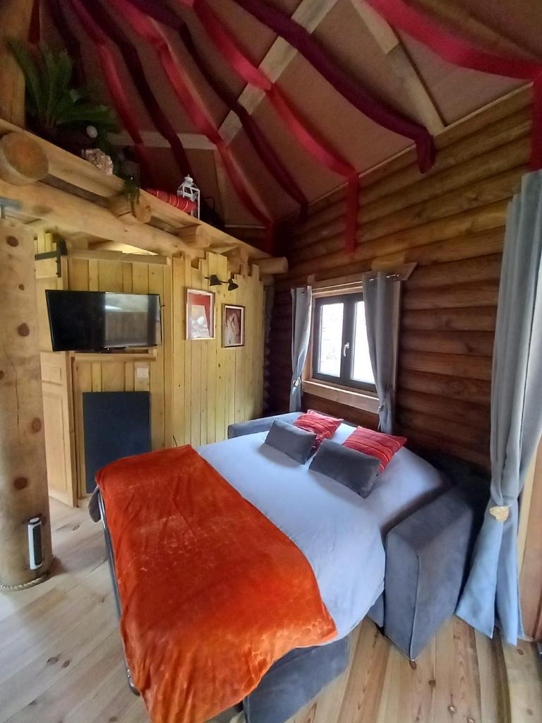 une chambre avec un lit dans une cabane en rondins dans l'établissement LA YOURTE DU RANDONNEUR, à Rimbach-près-Masevaux