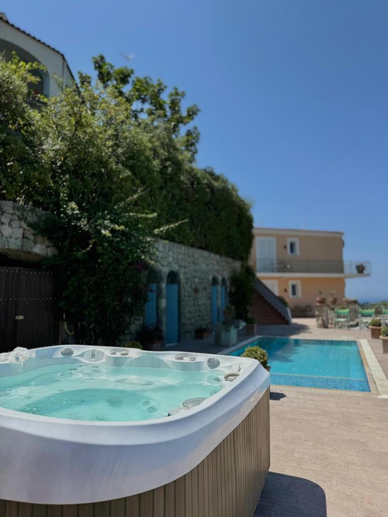 un jacuzzi à côté d'une piscine dans l'établissement Poggio Del Sole, à Ischia