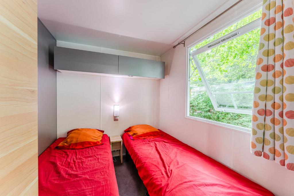 deux lits dans une petite pièce avec une fenêtre dans l'établissement Camping 4 étoiles, parc aquatique, à Aureilhan