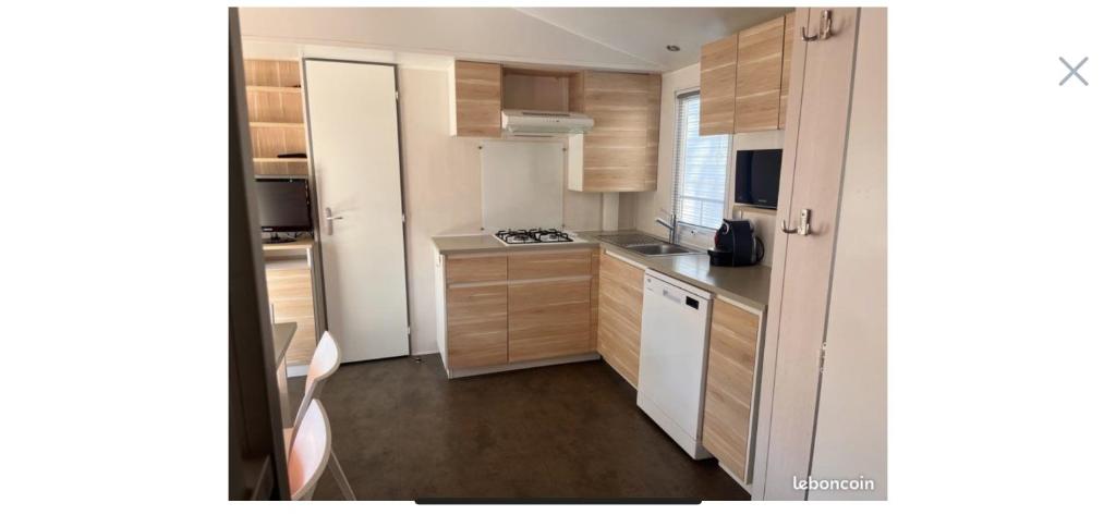 - une petite cuisine avec des placards en bois et des appareils blancs dans l'établissement Camping la sainte baume, à Nans-les-Pins