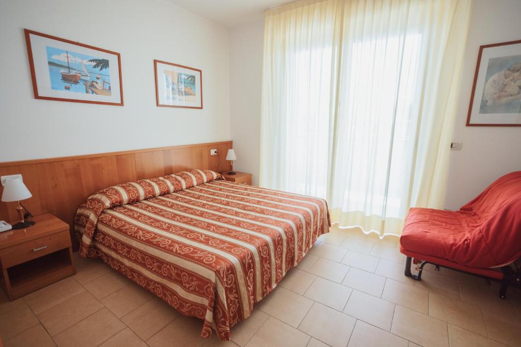 une chambre avec un lit, une chaise et une fenêtre dans l'établissement Hotel Santo Stefano, à Bibione