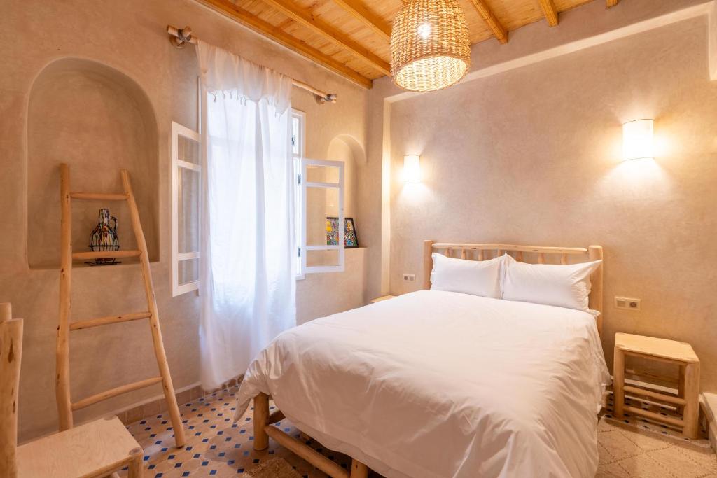 - une chambre avec un lit, une échelle et une fenêtre dans l'établissement Dar khadija, à Essaouira