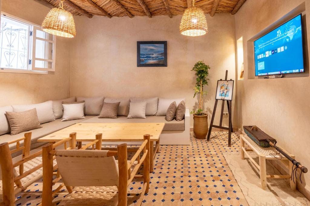 un salon avec un canapé et une télévision dans l'établissement Dar khadija, à Essaouira