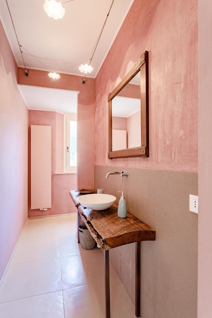 une salle de bain avec un lavabo et un miroir au mur dans l'établissement Villa Corte degli Ulivi, à Santa Maria Nuova