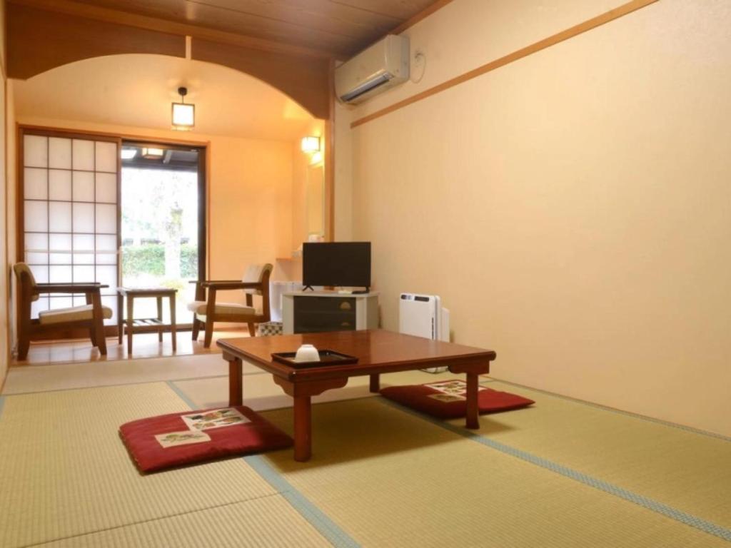 un salon avec une table et une télévision dans l'établissement Hiyoshi Forest Resort Yamanoie, à Nantan city 19 autres photos
