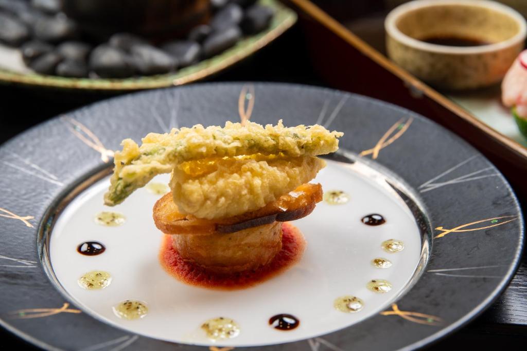 une assiette avec un morceau de nourriture dessus dans l'établissement Tsukasa Ryokan, à Saga