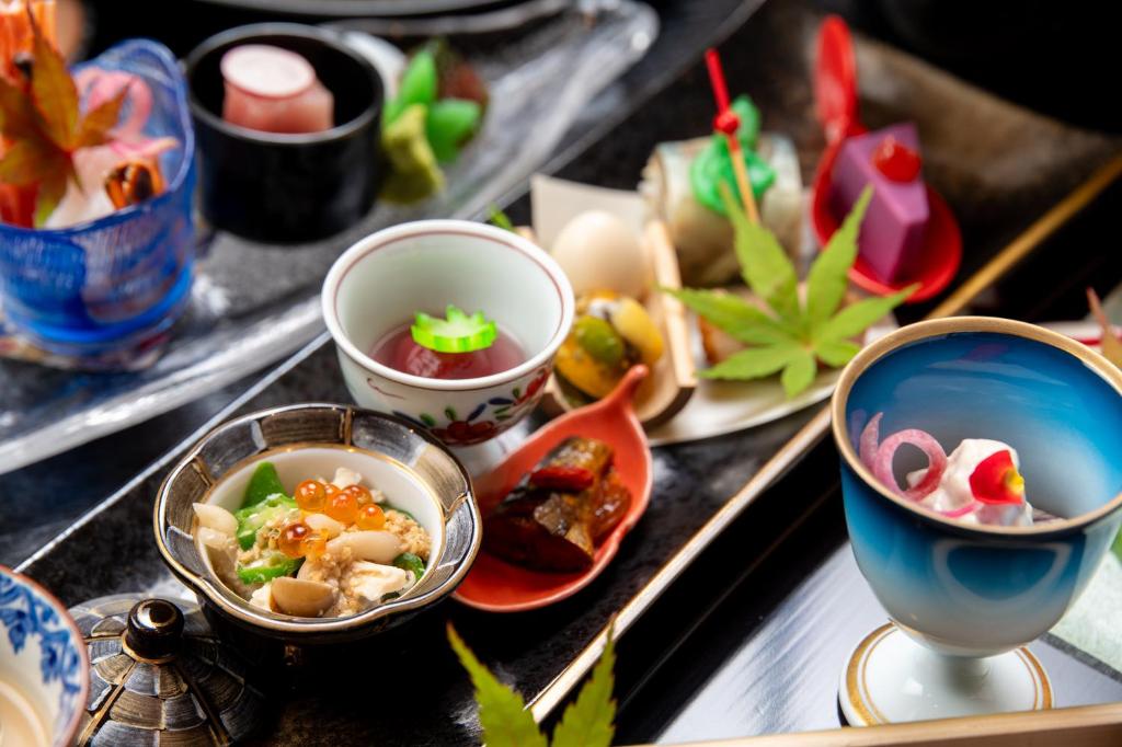 une table recouverte de bols et de assiettes de nourriture dans l'établissement Tsukasa Ryokan, à Saga