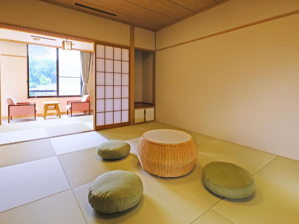 Cette chambre dispose d'une table et de deux ottomanes. dans l'établissement TAOYA Akiu, à Sendai