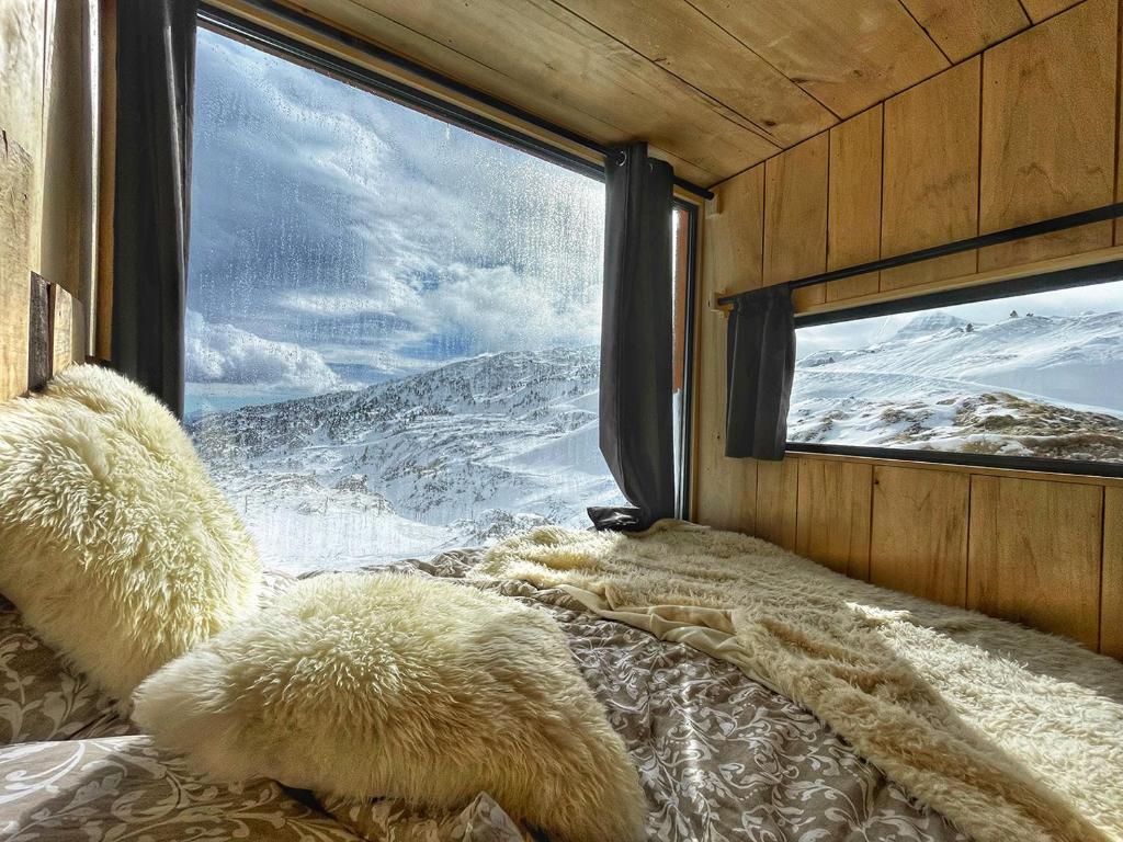 - une chambre avec une fenêtre offrant une vue sur une montagne enneigée dans l'établissement atipic lodge, à Arette