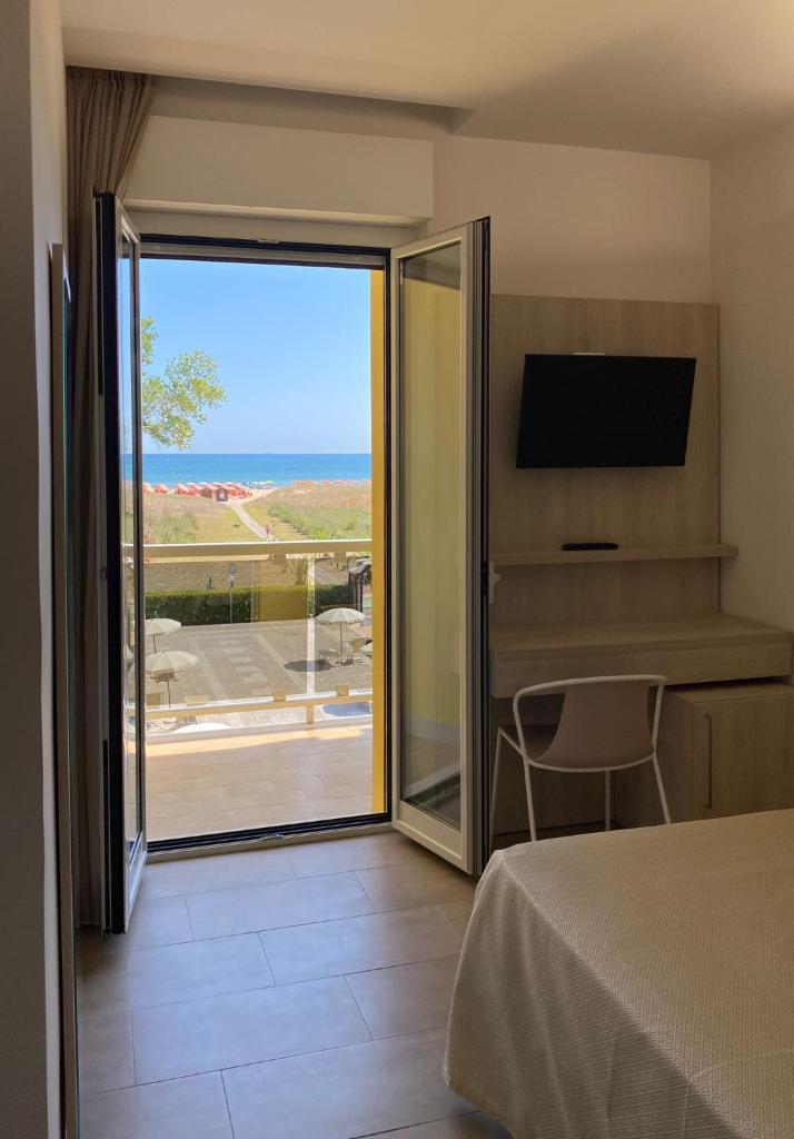 - une chambre avec une porte coulissante en verre offrant une vue sur l'océan dans l'établissement Hotel Vittoria, à Vasto